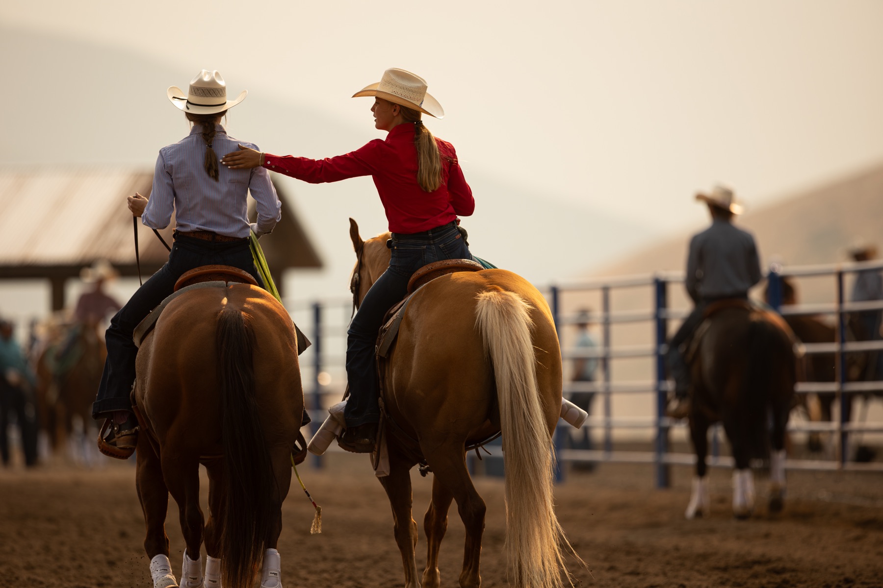 Young riders on ranch horses at sunset